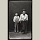 Father Sitting, Son Standing, Both with Hats